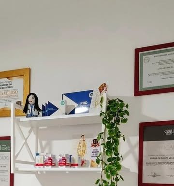 Prateleira do consultório com certificados e diplomas emoldurados